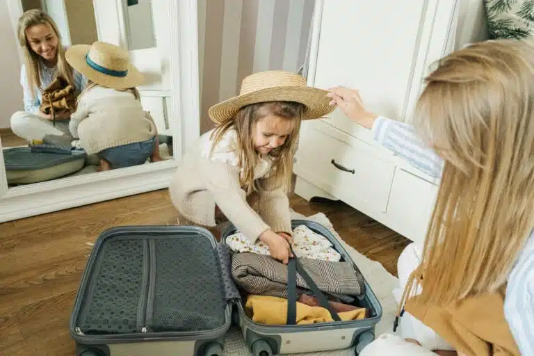 A mother and daughter pack a suitcase for a summer vacation, creating joyful memories.