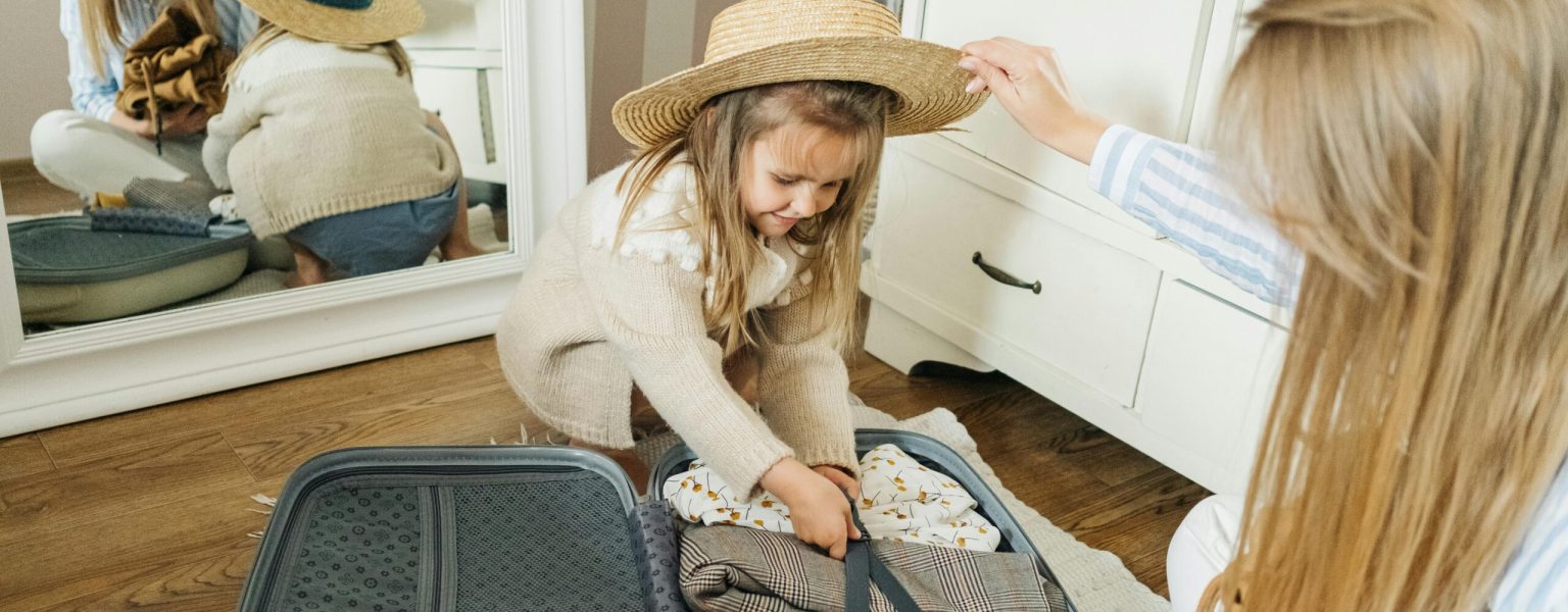 A mother and daughter pack a suitcase for a summer vacation, creating joyful memories.